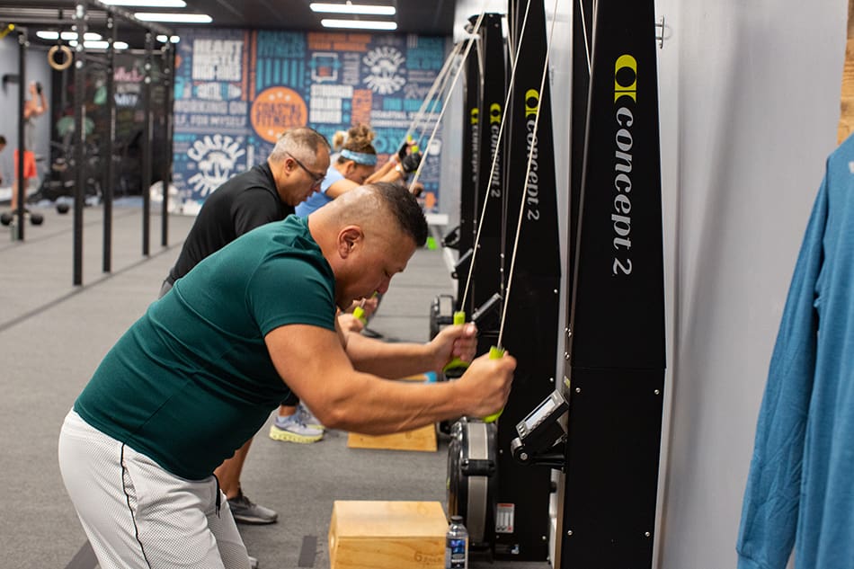 Group personal training class, members working out at Coastal Fitness using Skierg machines