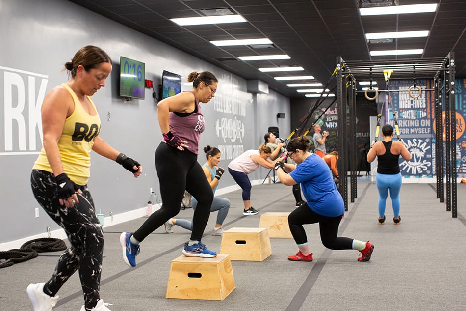 Coastal Fitness members doing box step-ups during class.