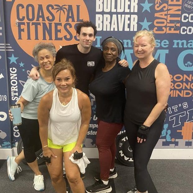 Fit Forever members standing with Coastal Fitness coach
