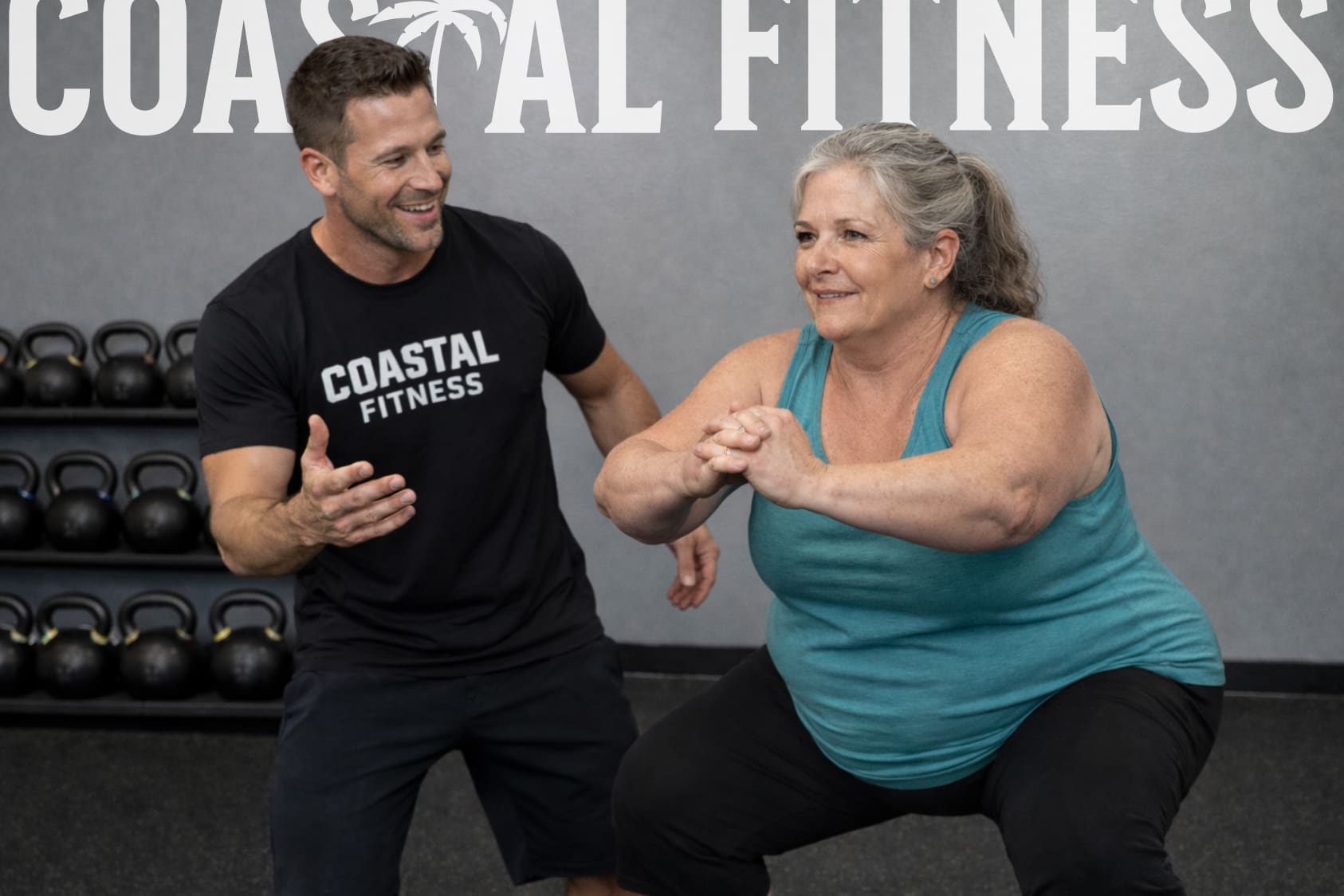 Personal trainer coaching member performing squat
