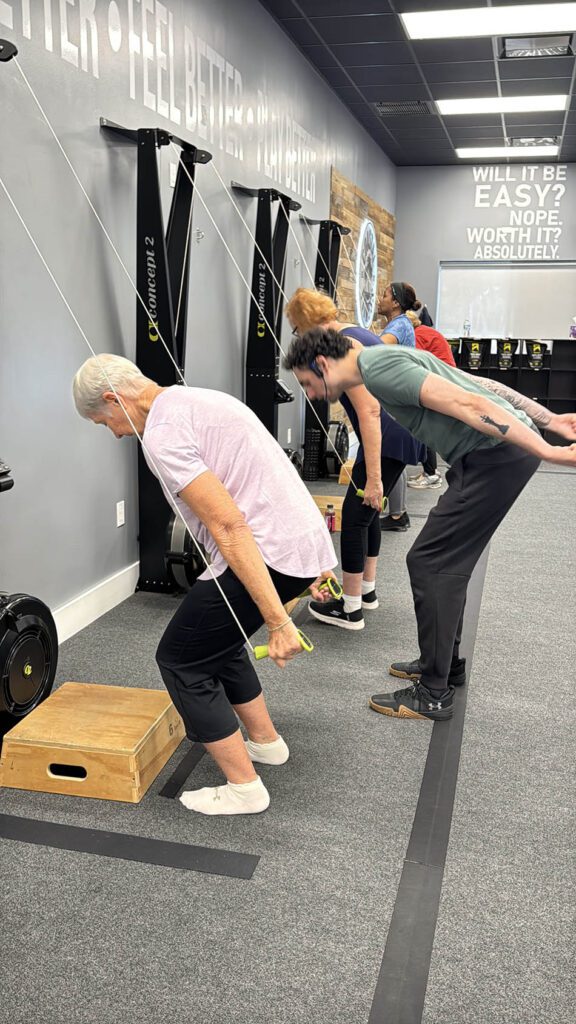 Coastal Fitness coach guiding 55 and older members through strength training workout