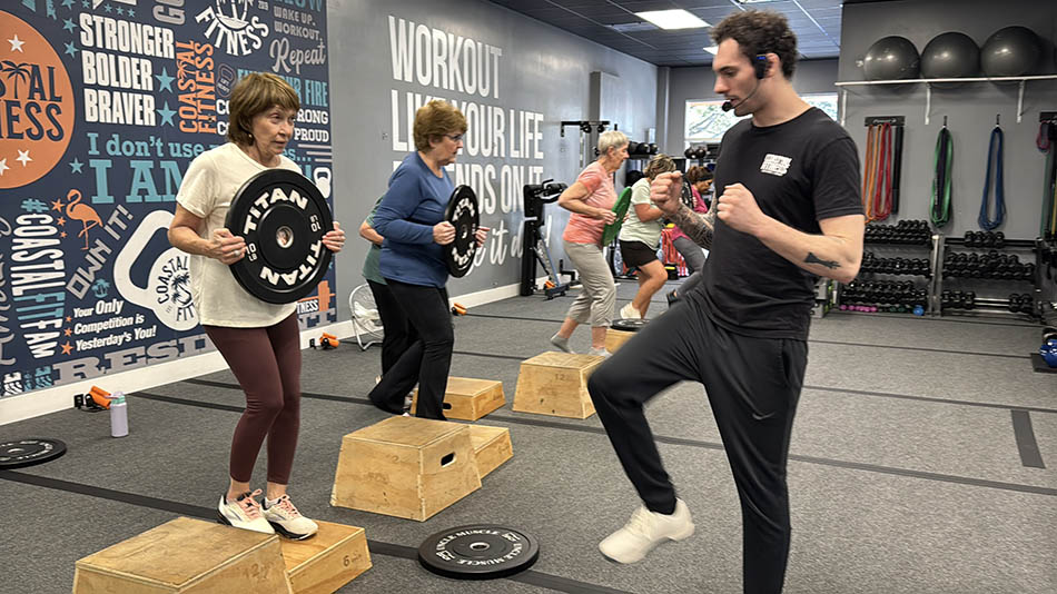 Coastal Fitness coach guiding 55 and older members through strength training workout