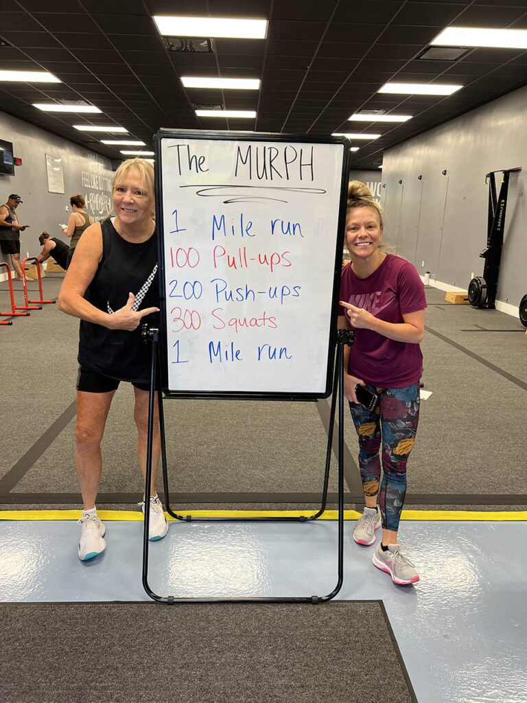 Mother/daughter duo pose for a photo after The Murph at Coastal Fitness