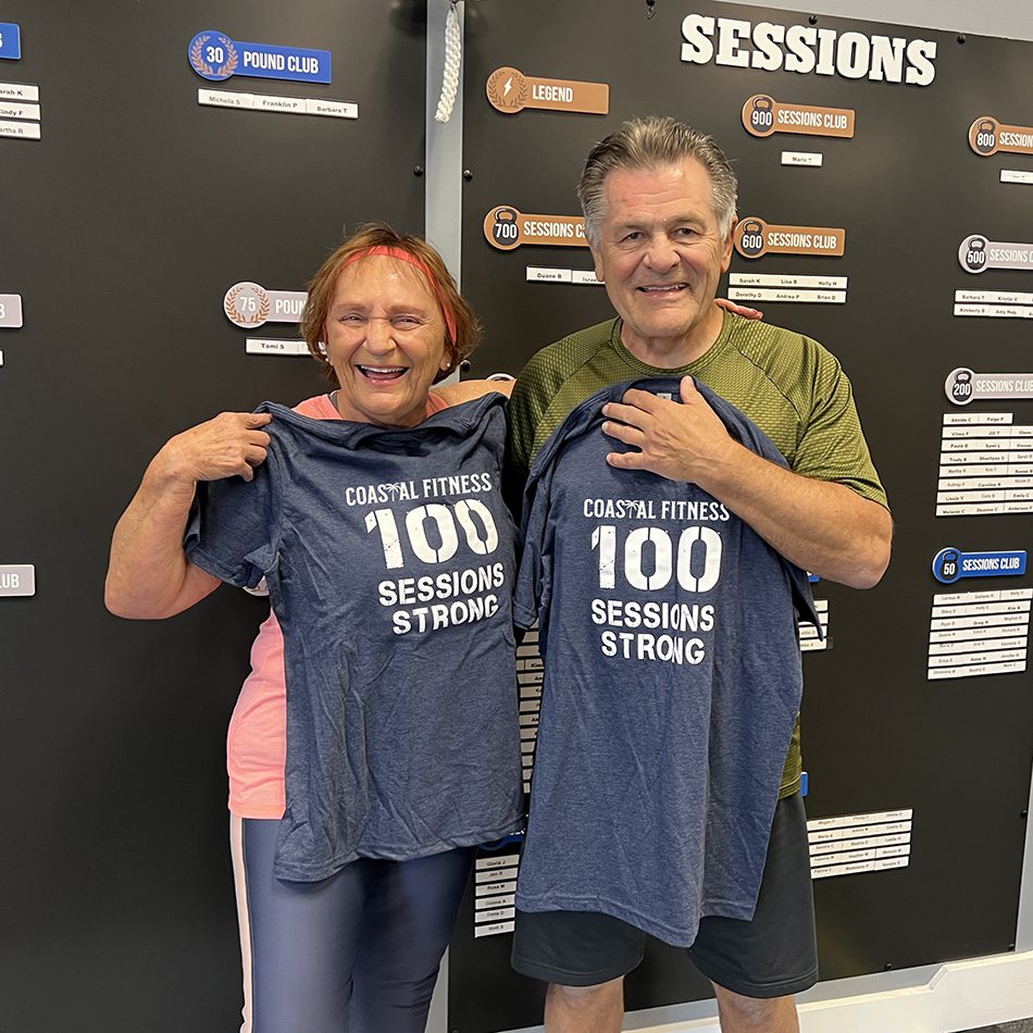 A couple at Coastal Fitness poses for a celebration photo for completing a major milestone.
